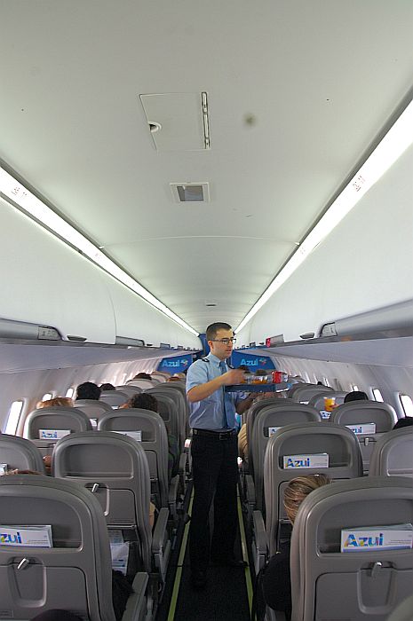 O comissário serve bebidas aos passageiros