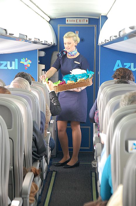 A comissária oferece snacks aos clientes da companhia