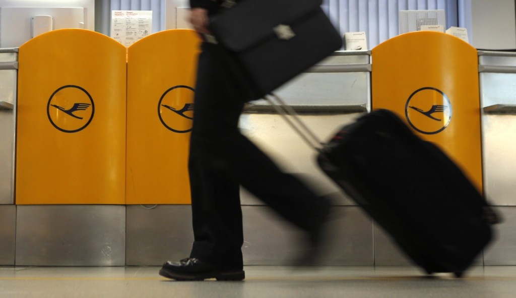 A passenger walks past a ticket counter of German air carrier Lufthansa at Berlin Tegel airport April 2, 2014. The union for Lufthansa pilots, Vereinigung Cockpit, called a strike for its members to demand higher wages and the airline had to cancel more than 3,800 flights. REUTERS/Fabrizio Bensch (GERMANY - Tags: TRANSPORT BUSINESS EMPLOYMENT SOCIETY)