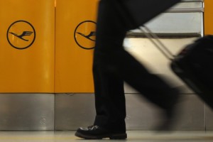 A passenger walks past a ticket counter of German air carrier Lufthansa at Berlin Tegel airport April 2, 2014. The union for Lufthansa pilots, Vereinigung Cockpit, called a strike for its members to demand higher wages and the airline had to cancel more than 3,800 flights. REUTERS/Fabrizio Bensch (GERMANY - Tags: TRANSPORT BUSINESS EMPLOYMENT SOCIETY)