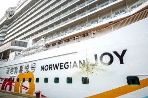 NCL batiza Norwegian Joy em cerimônia luxuosa na China Garrafa de Champagne explode contra o casco do navio em clássica superstição