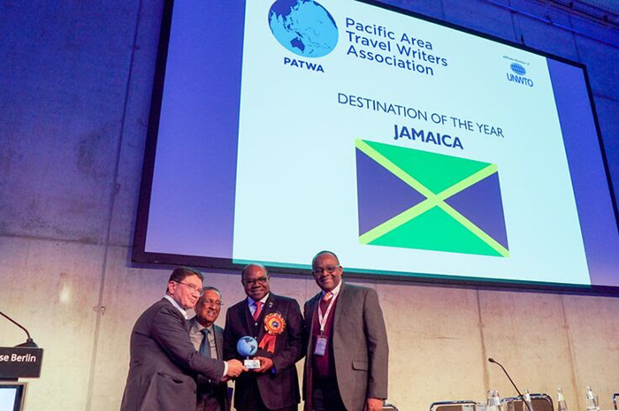 O Diretor de Turismo da Jamaica, Donovan White (à direita) e o Ministro do Turismo, Hon. Edmund Bartlett (segundo à direita), aceitam o prêmio de Destino do Ano, concedido pela Associação dos Escritores de Turismo da Região do Pacífico das mãos do ex-Secretário Geral das Nações Unidas, Dr. Taleb Raifi ( à esquerda) e do Secretário Geral da PATWA, Sagar Ahluwalia
