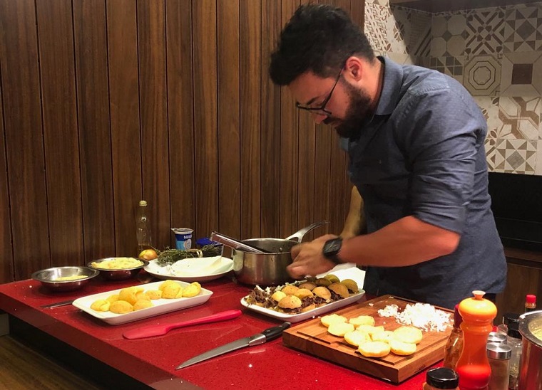 Chef Fábio Marques, de Brasília, está entre os anfitriões da plataforma. Na foto, ele prepara jantar tipicamente mineiro, que inclui pão de queijo recheado com carne suína. Crédito: Divulgação/MTur
