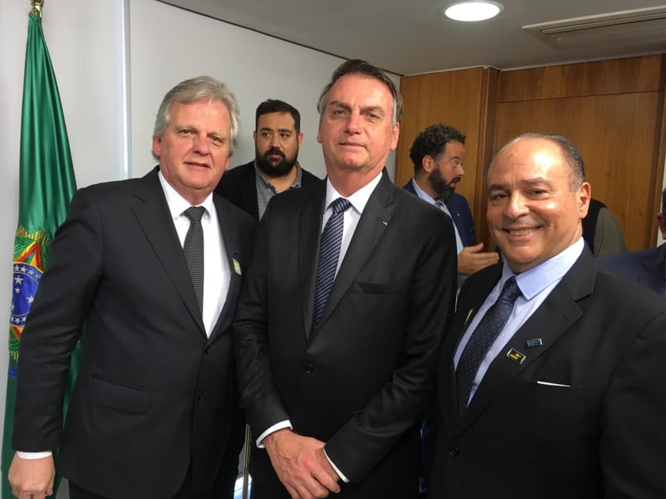 O presidente Jair Bolsonaro entre Edmar Bull e Geraldo Rocha, da Abav Nacional