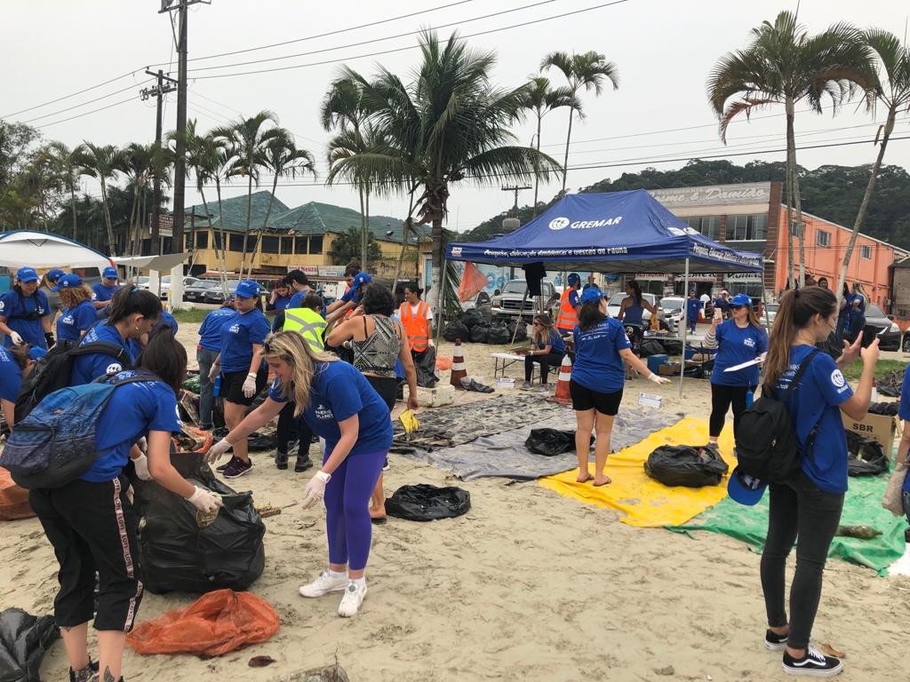 Agentes de viagens durante limpeza da praia no litoral de São Paulo