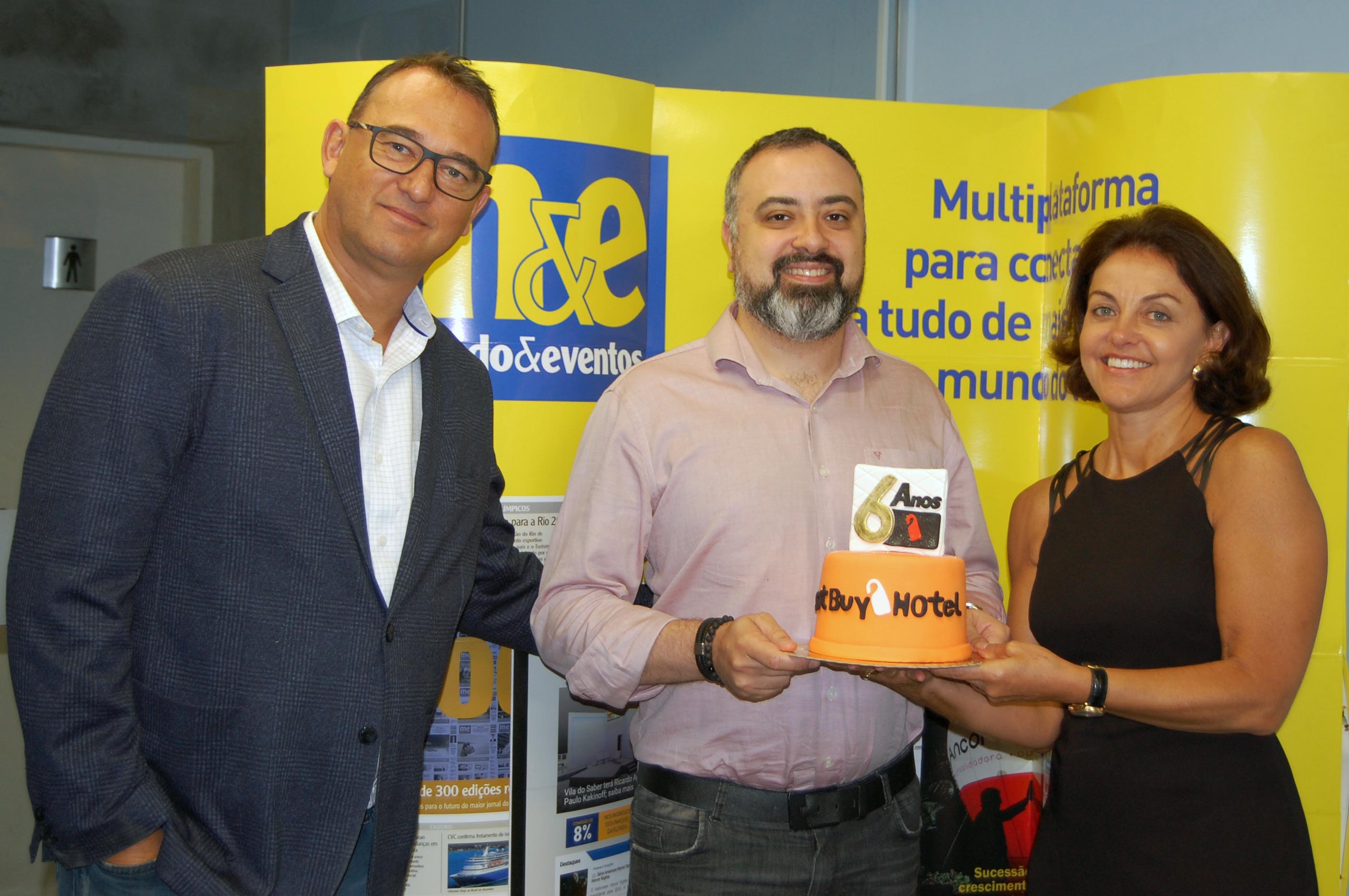 Best Buy Hotel completa seis anos de operação e sinergia com agente de viagens 2 Anderson Masetto, do M&E, recebe o bolo de comemoração de seis anos da Best Buy, de Victor e Nice van Oorchot, CEO e diretora de Operações da operadora