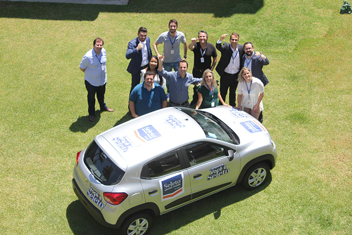 Equipe da Flytour ao lado do carro que será entregue ao agente de viagens vencedor da campanha