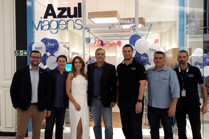 Daniel Bicudo (segundo, da esquerda para direita), diretor da Azul Viagens, e Alessandra Perez (vestido branco), proprietária da nova loja da Azul Viagens, celebram juntos com Tripulantes da operadora de turismo a expansão da unidade de negócios da Azul