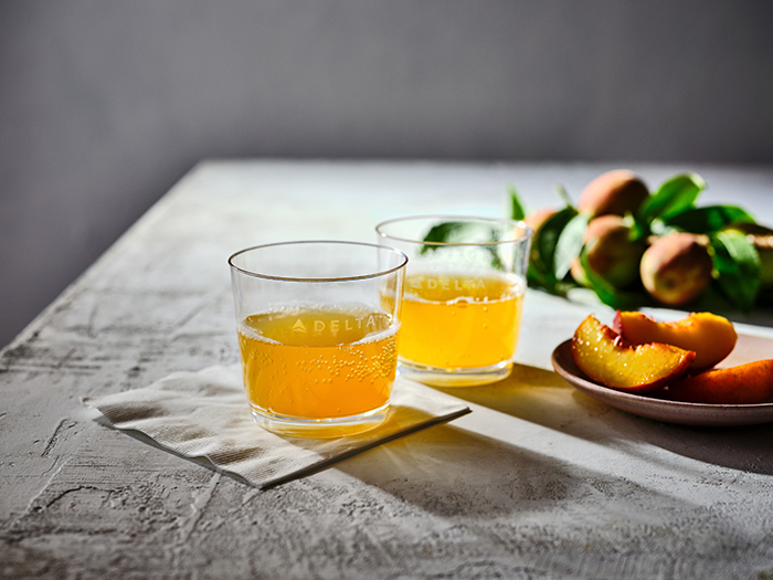 Two bellinis in Delta tumblers next to a plate of sliced peaches License expiration date: None Media: All uses except broadcast permitted Territory: Worldwide These images are protected by copyright. Delta has acquired permission from the copyright owner to the use the images for specified purposes and in some cases for a limited time. If you have been authorized by Delta to do so, you may use these images to promote Delta, but only as part of Delta-approved marketing and advertising. Further distribution (including providing these images to third parties), reproduction, display, or other use is strictly prohibited.