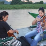 Durante o passeio do pôr do sol, músicos tocam ao vivo em pequenos botes ao entardecer