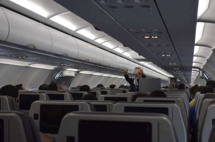Iata: pesquisa revela preocupação dos viajantes com a Covid-19 1 Comissária de bordo passando as orientações no início do voo