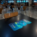 Mesas da praça de alimentação lembram das recomendações com a higiene Mesas da praça de alimentação lembram das recomendações com a higiene