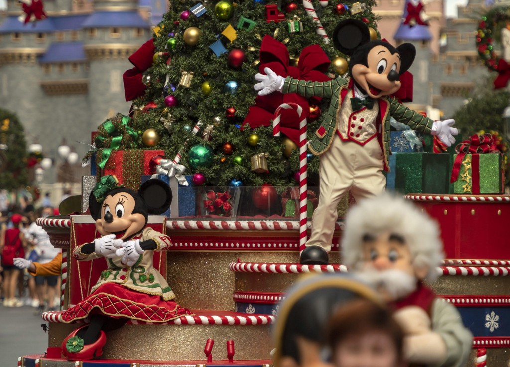 Minnie Mouse (left) and Mickey Mouse (right) wave to guests during their cavalcade down Main Street, U.S.A., as part of the holiday celebrations at Magic Kingdom Park at Walt Disney World Resort in Lake Buena Vista, Fla. (Kent Phillips, photographer)