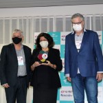 Marcelo Matera e Luiz Claudio Tomba entregam o prêmio à Jussara Haddad, do consulado dos Estados Unidos