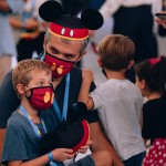 Pai e filho curtem o evento com chapéu e máscara do Mickey