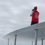 Do alto do catamarã, marinheiro orienta para avistamento de baleias e golfinhos