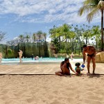 Família fazendo castelo de areia na praia do Hot Beach
