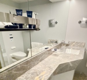 Banheiro da cabine do YC, revestido de mármore e equipado com amenidades 