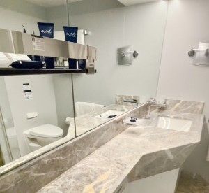 MSC Yacht Club: veja como é a experiência na área mais exclusiva e luxuosa do MSC Seaview 4 Banheiro da cabine do YC, revestido de mármore e equipado com amenidades