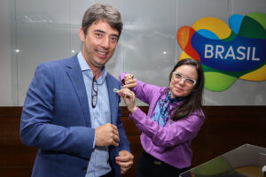 Fabricio Amaral, presidente do Fornatur, recebe o pin da Marca Brasil de Jaqueline Gil