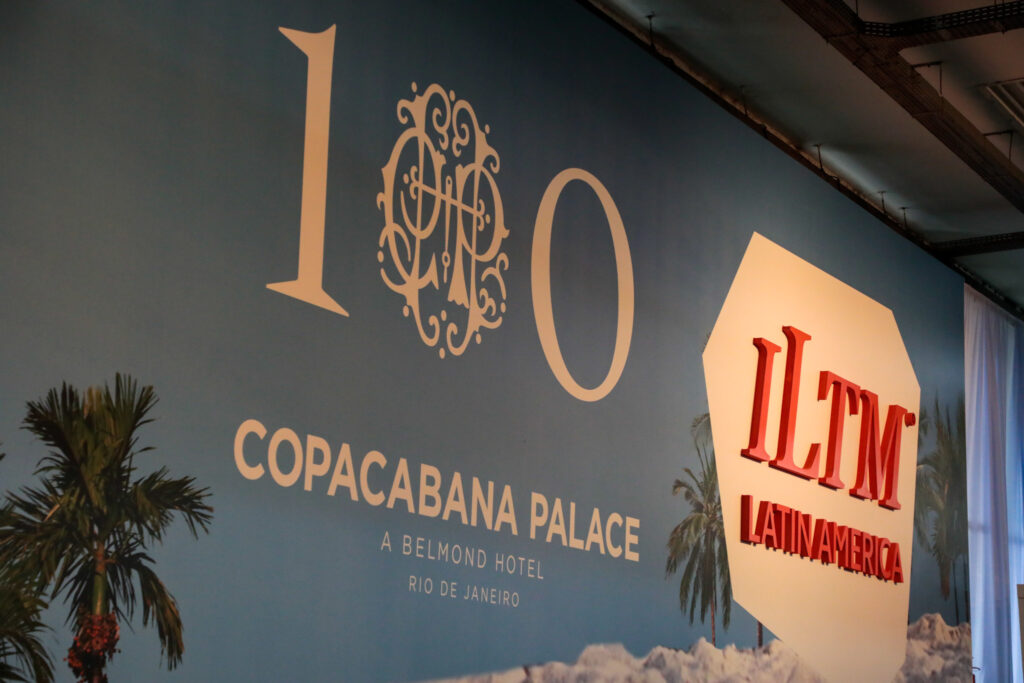 Painel dos 100 anos do Copacabana Palace ao lado do letreiro da ILTM Latin America