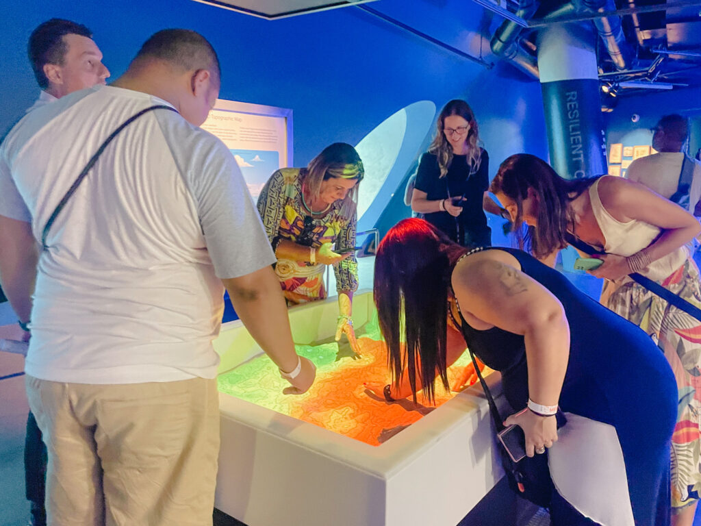 Agentes de viagens interagindo com a instalação científica no Frost Museum