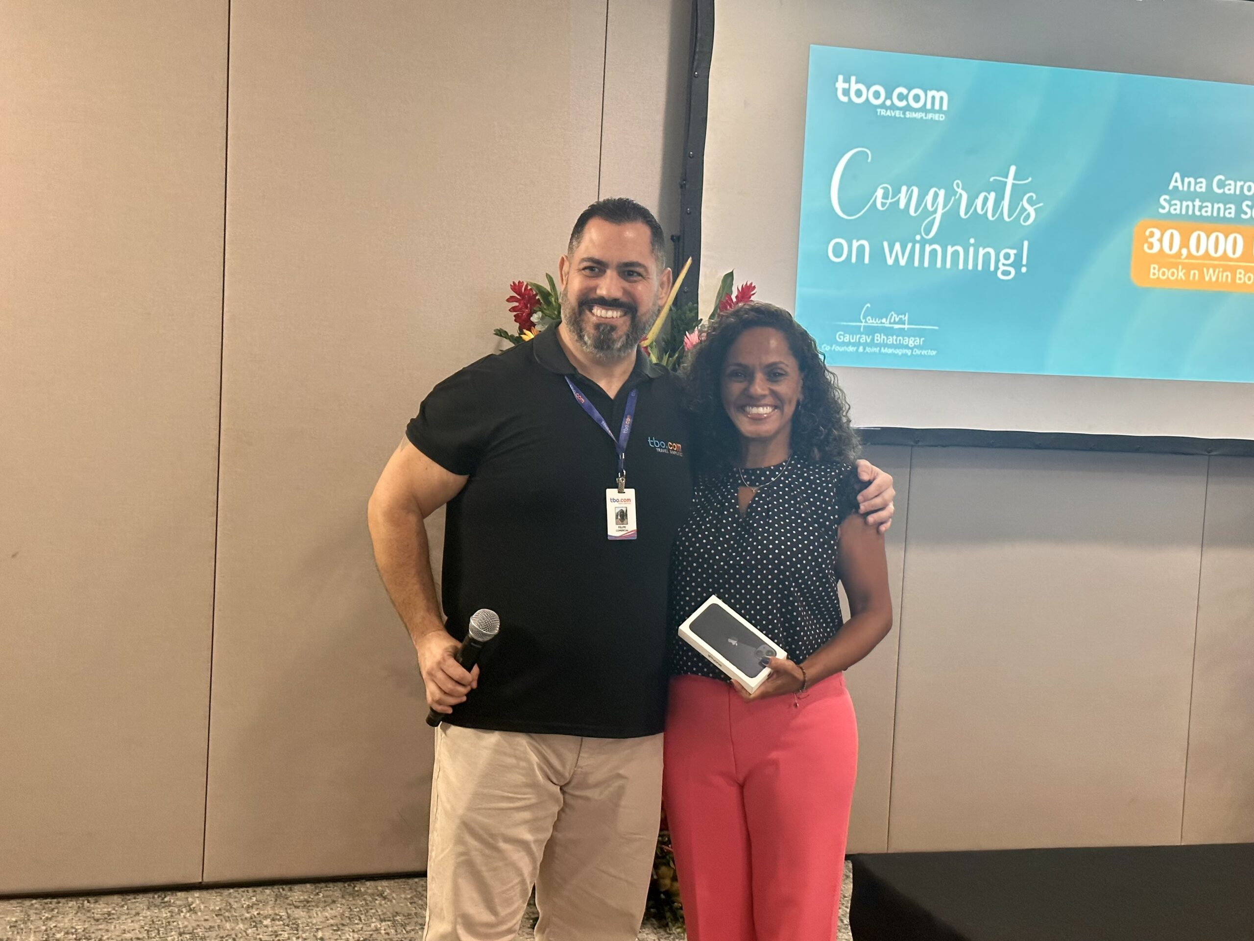 Patrícia Guimarães, da GBOND Travel, recebeu iPhone das mãos de Felipe Anjos, executivo de vendas da TBO.com Patrícia Guimarães, da GBOND Travel, recebeu iPhone das mãos de Felipe Anjos, executivo de vendas da TBO.com