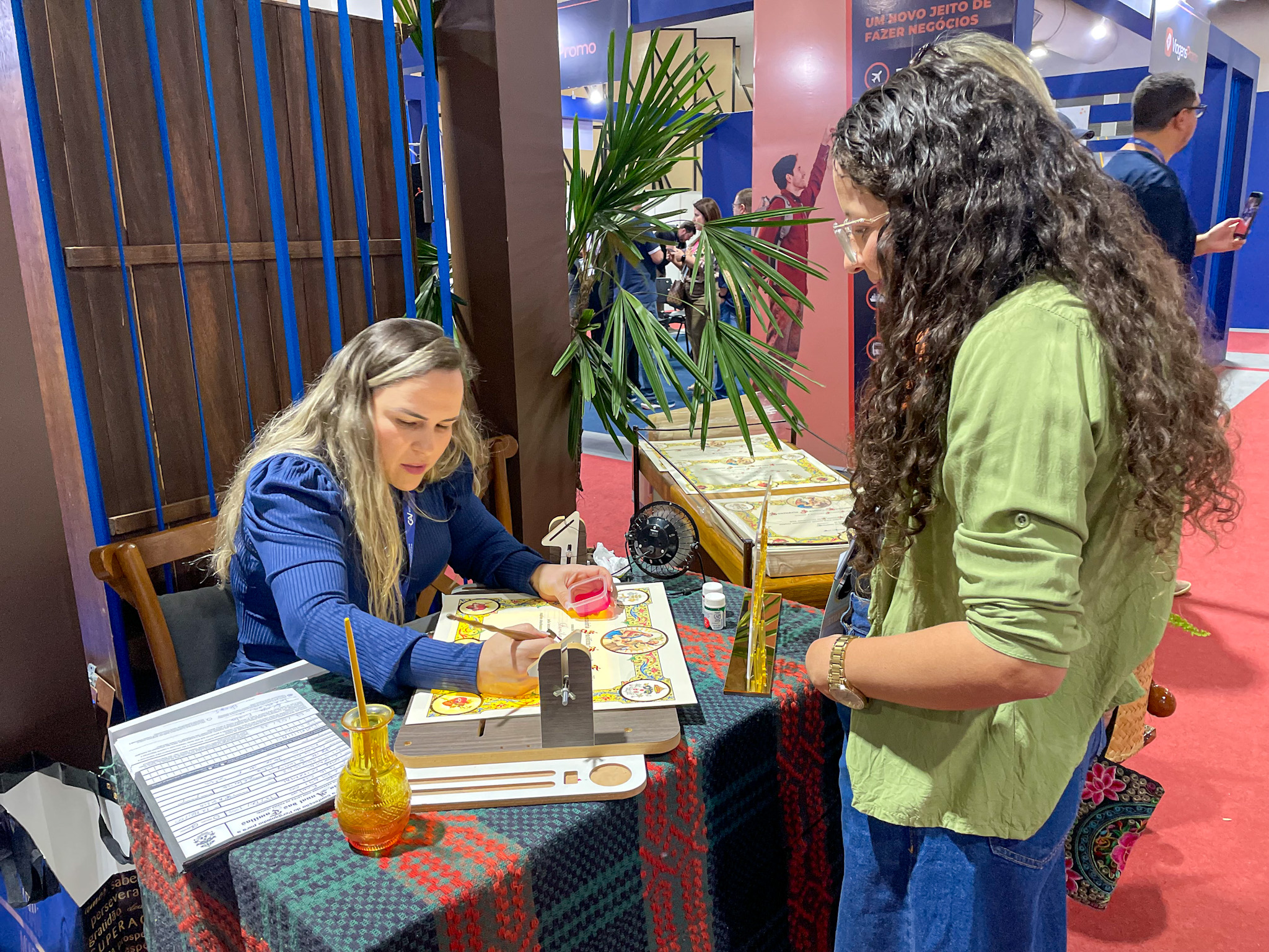Profissional especialista em caligrafia criando um certificado manual para os visitantes da feira Profissional especialista em caligrafia criando um certificado manual para os visitantes da feira