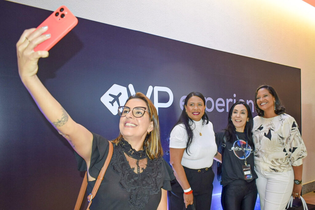 Agentes de viagens fazendo selfie no background do evento VPExperience