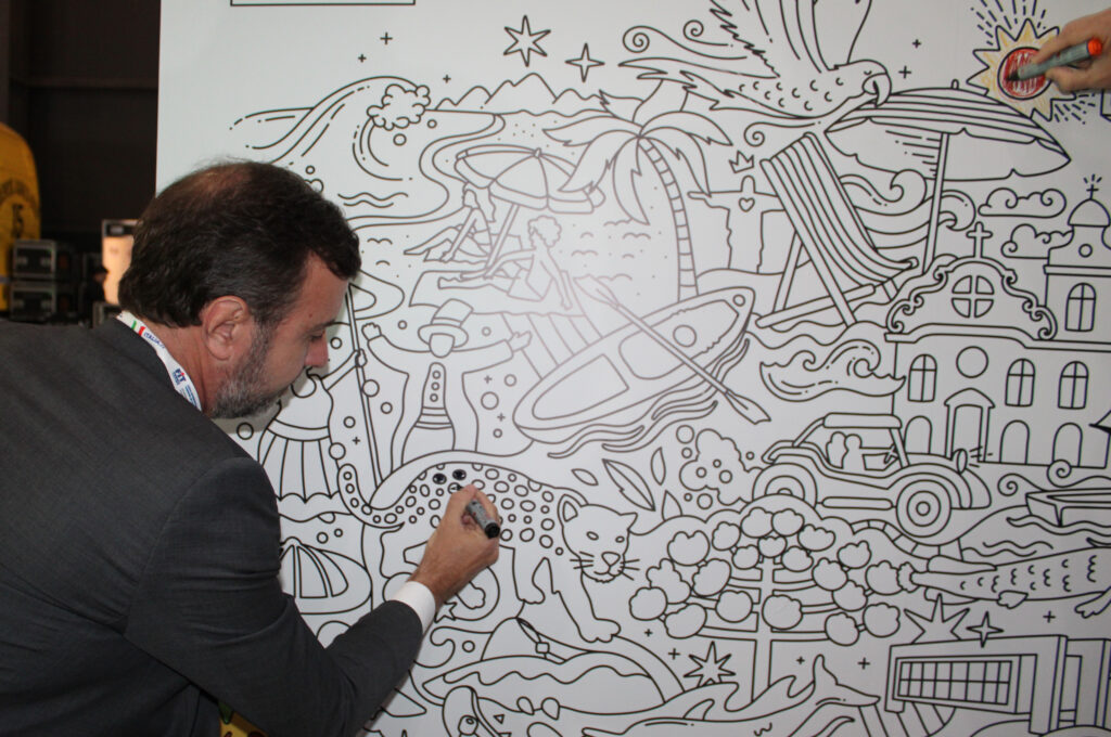 Marcelo Freixo, presidente da Embratur, pinta o mural no estande do Brasil