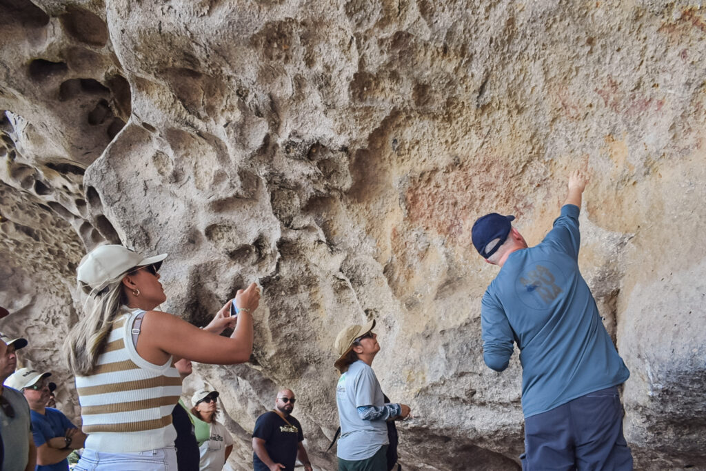 Explicação do guia sobre as artes rupestres gravadas na cavernas