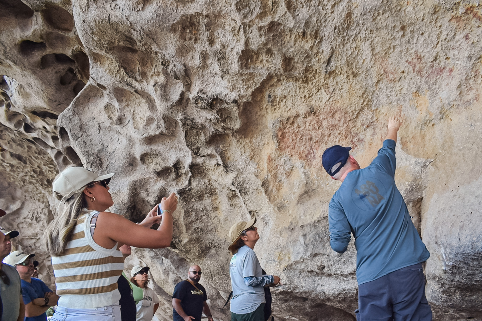 Explicação do guia sobre as artes rupestres gravadas na cavernas