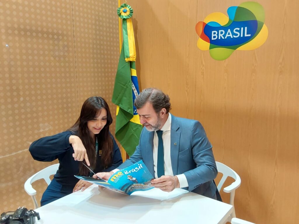 Natália Strucchi, diretora de Redação do M&E, mostrando a revista especial do M&E, produzida para a WTM London, para o presidente da Embratur, Marcelo Freixo