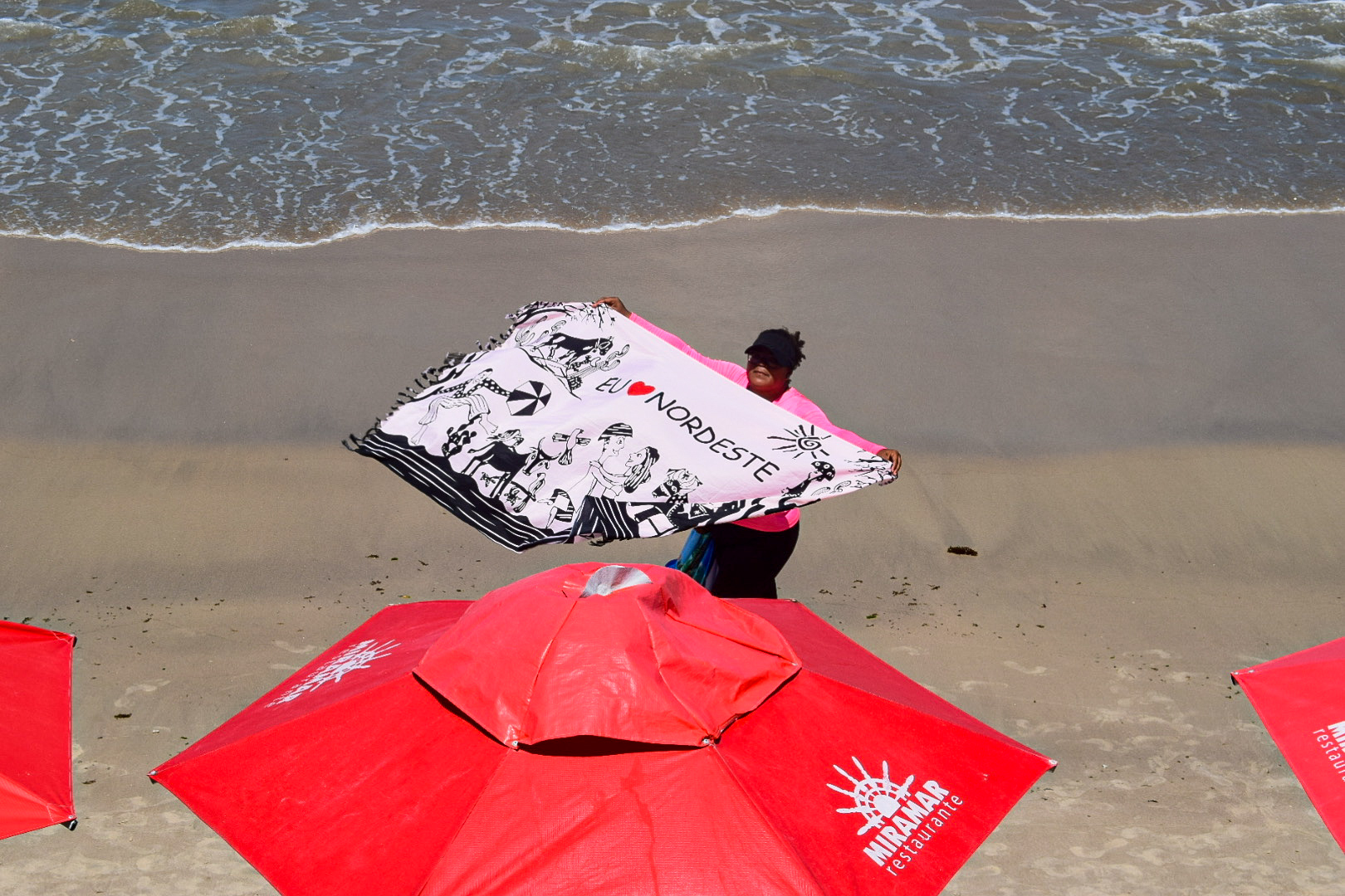 Vendedores ambulantes oferecem peças de vestuário na praia Vendedores ambulantes oferecem peças de vestuário na praia