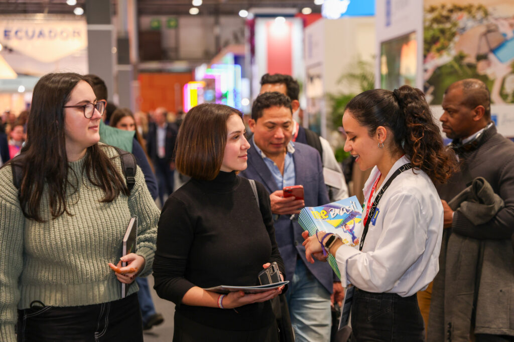 Recepcionista entregando a edição especial do Mercado&Eventos na FITUR 2024