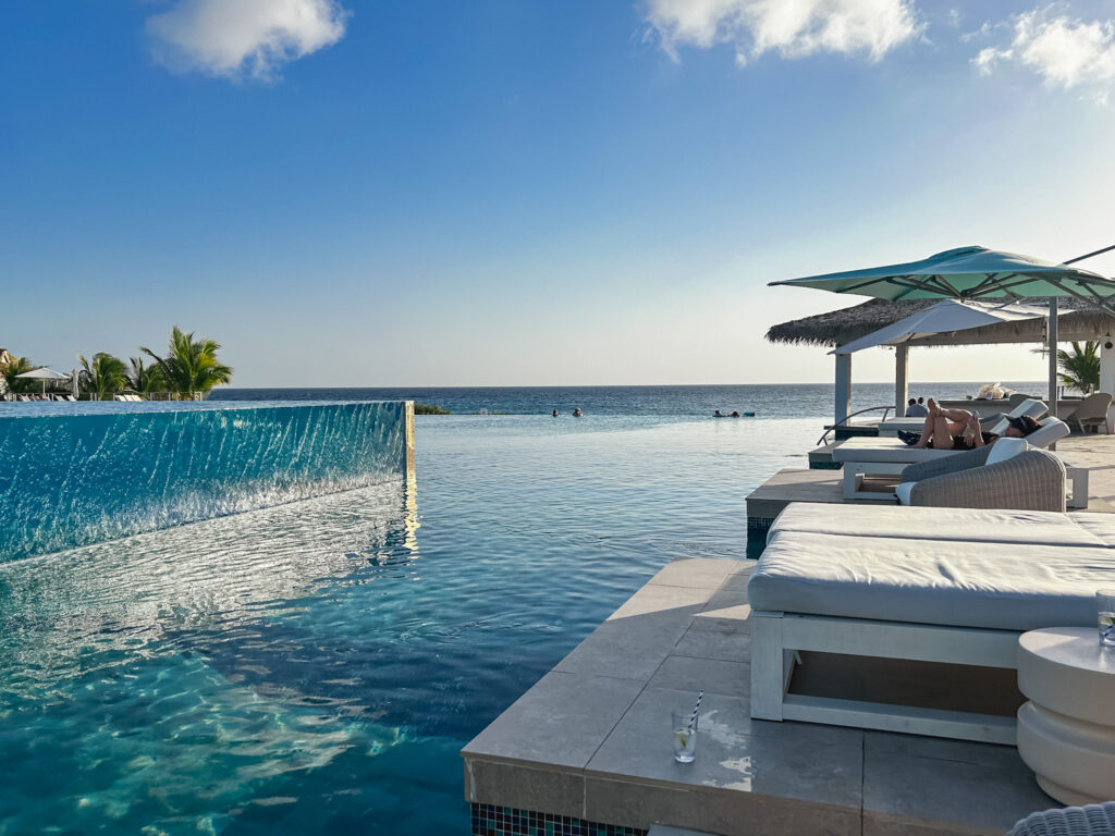 A piscina principal do Sandals Curaçao possui dois níveis e borda infinita, dando sensação de conexão com o mar