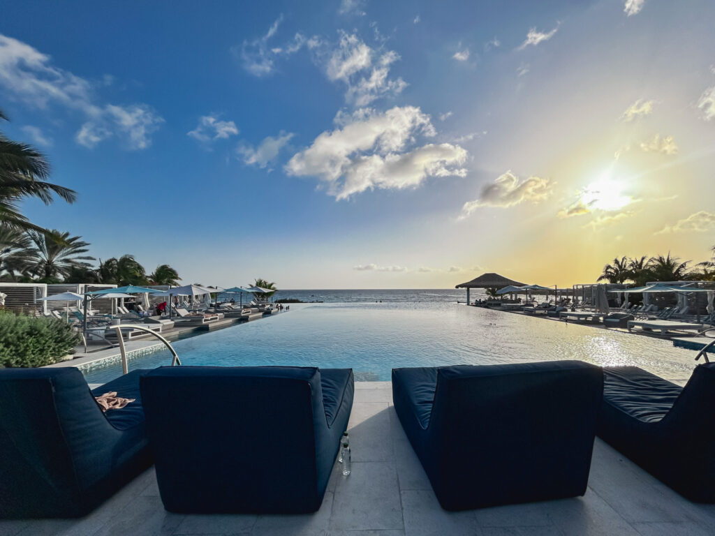 Vista da piscina de borda infinita para o mar no pô do sol, no hotel Sandals Curaçao