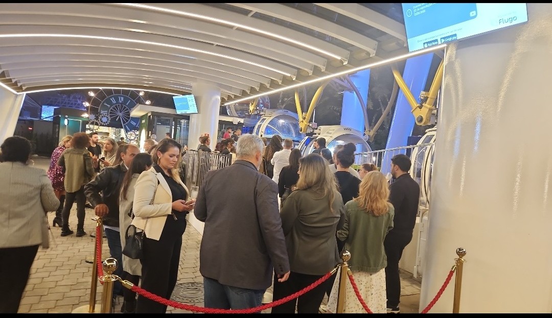 Convidados na fila para subir na roda-gigante Convidados na fila para subir na roda-gigante