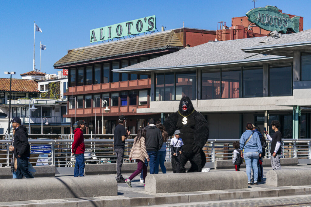 Nas ruas de Fisherman's Wharf, pessoas se fantasiam e tocam música para os transeuntes