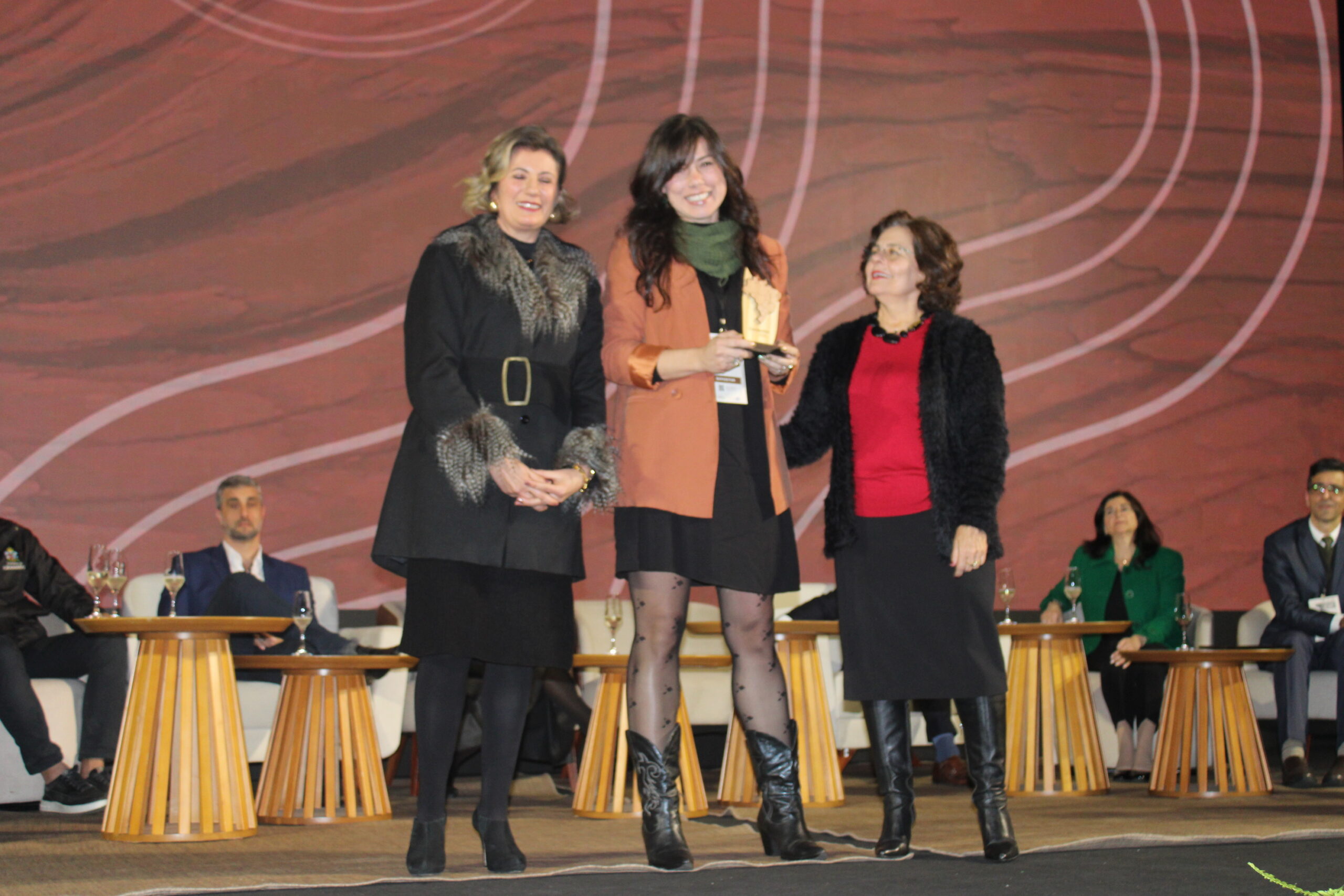 Jaqueline Corradi, expoositora do Vale do Jamari (RO) recebe troféu de representantes do Sebrae Jaqueline Corradi, expoositora do Vale do Jamari (RO) recebe troféu de representantes do Sebrae