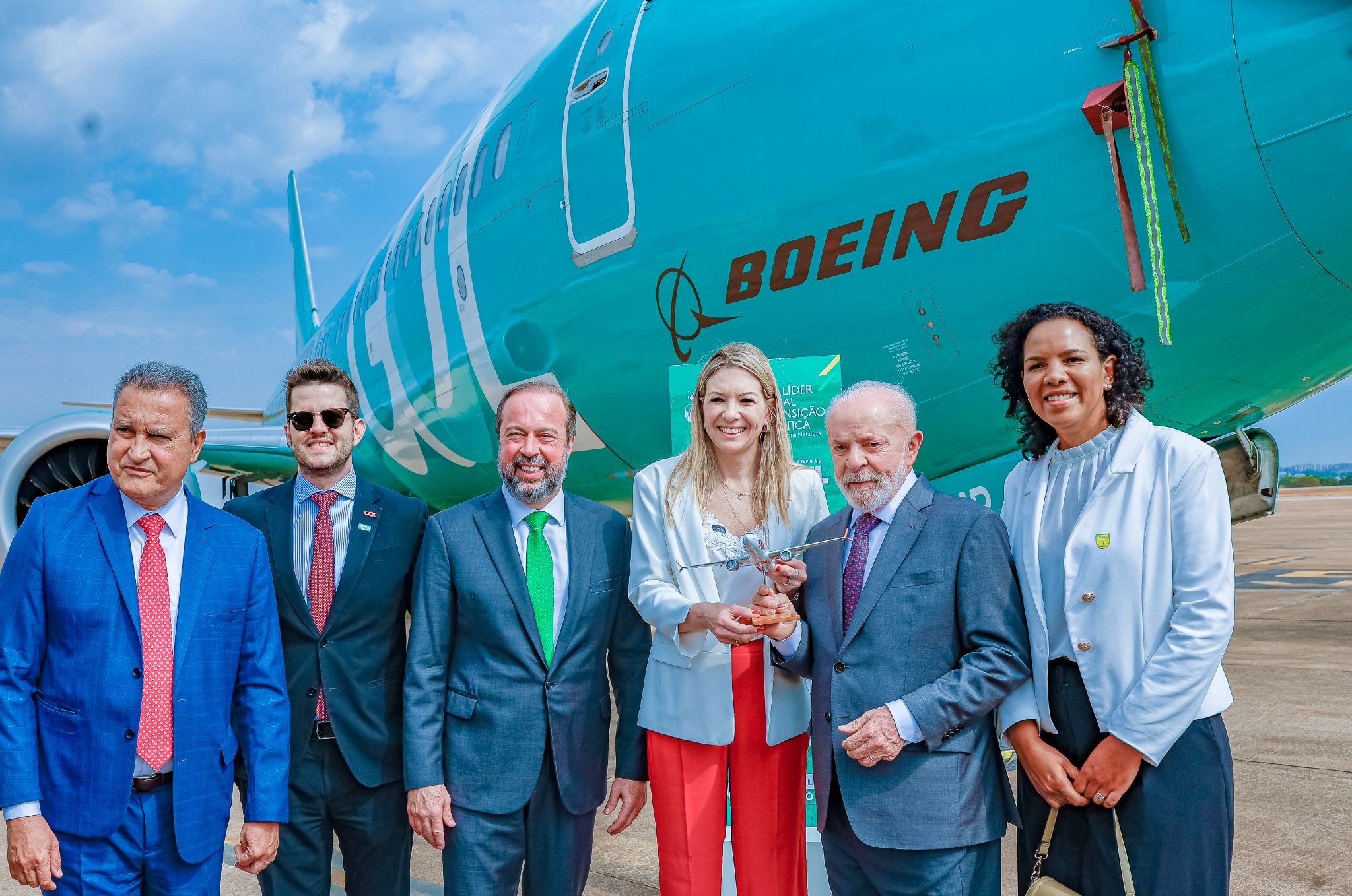 Gol leva aeronave verde ao evento de sanção da Lei do Combustível do Futuro, em Brasília 1 Em Brasília na manhã desta terça-feira (8), Renata Fonseca, Chief Legal Officer (CLO) e diretora executiva de Relações Institucionais e Governamentais da GOL, presenteia o presidente Luiz Inácio Lula da Silva com uma maquete de aeronave Boeing da Companhia; a partir da esq., Rui Costa, ministro da Casa Civil; Felippe Bandeira Ramos Coelho, gerente de Relações Governamentais da GOL; e Alexandre Silveira, ministro de Minas e Energia. À dir., Jurema Monteiro, presidente da Abear (Reprodução/Ricardo Stuckert/Presidência da República)