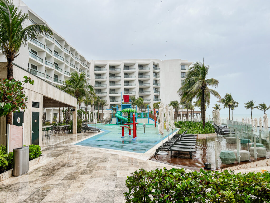 O parque aquático infantil e a piscina principal estão próximos no Hilton Cancún All Inclusive