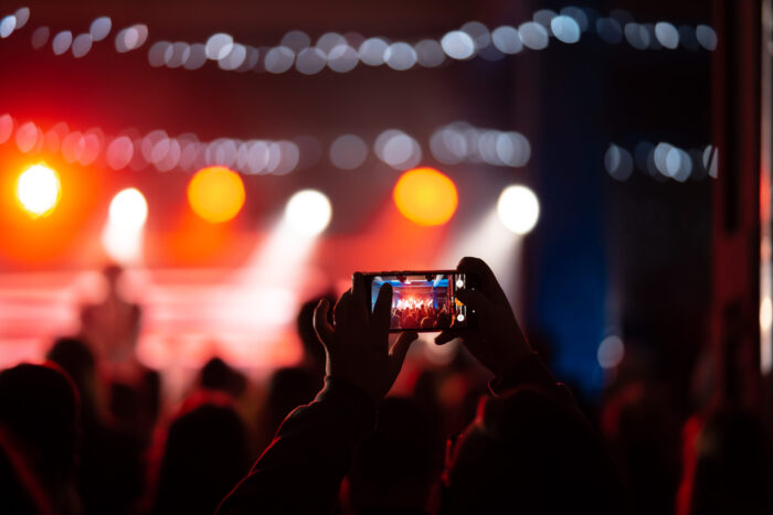 'Live Tourism': conheça a tendência que promete transformar o setor em 2025 1 close up recording video with smartphone concert toned picture scaled e1734363285294 'Live Tourism': conheça a tendência que promete transformar o setor em 2025