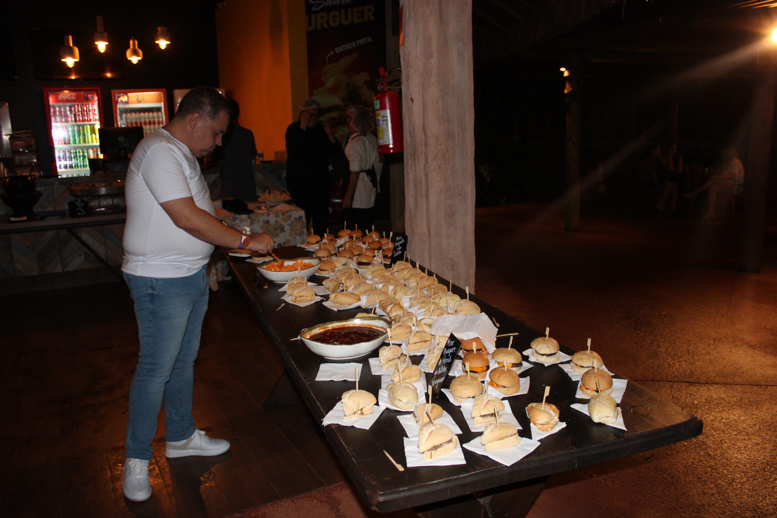 Mesa com hamburgueres e vários petiscos durante a festa Mesa com hamburgueres e vários petiscos durante a festa