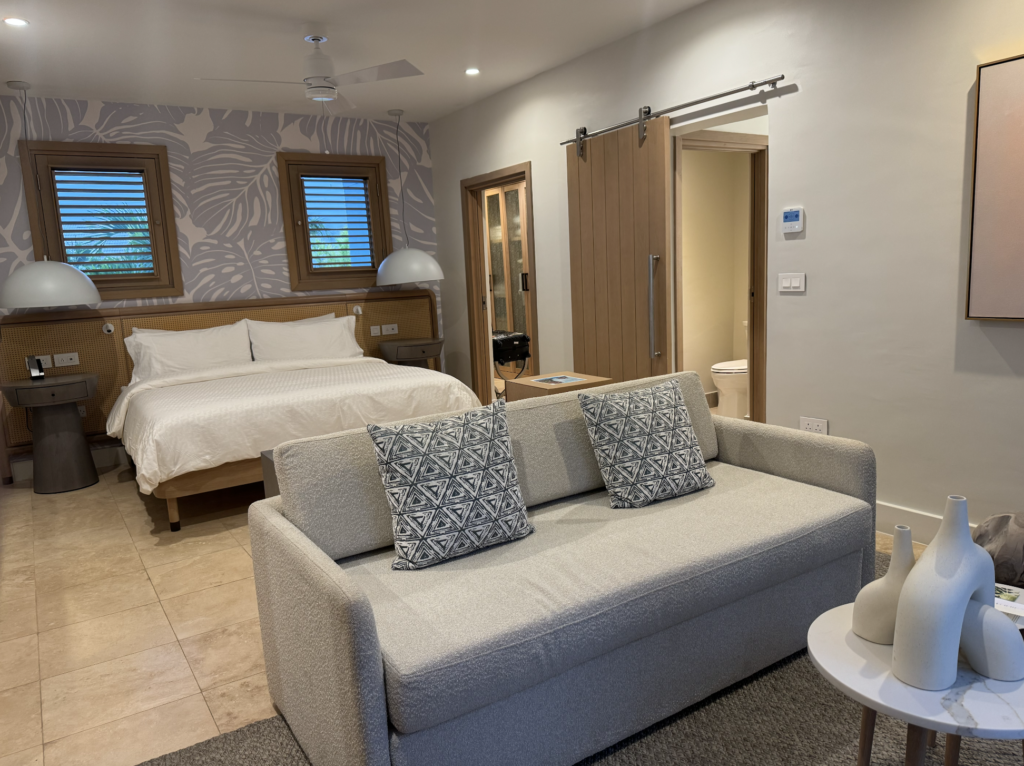 Cama king size e sofá de um dos apartamentos