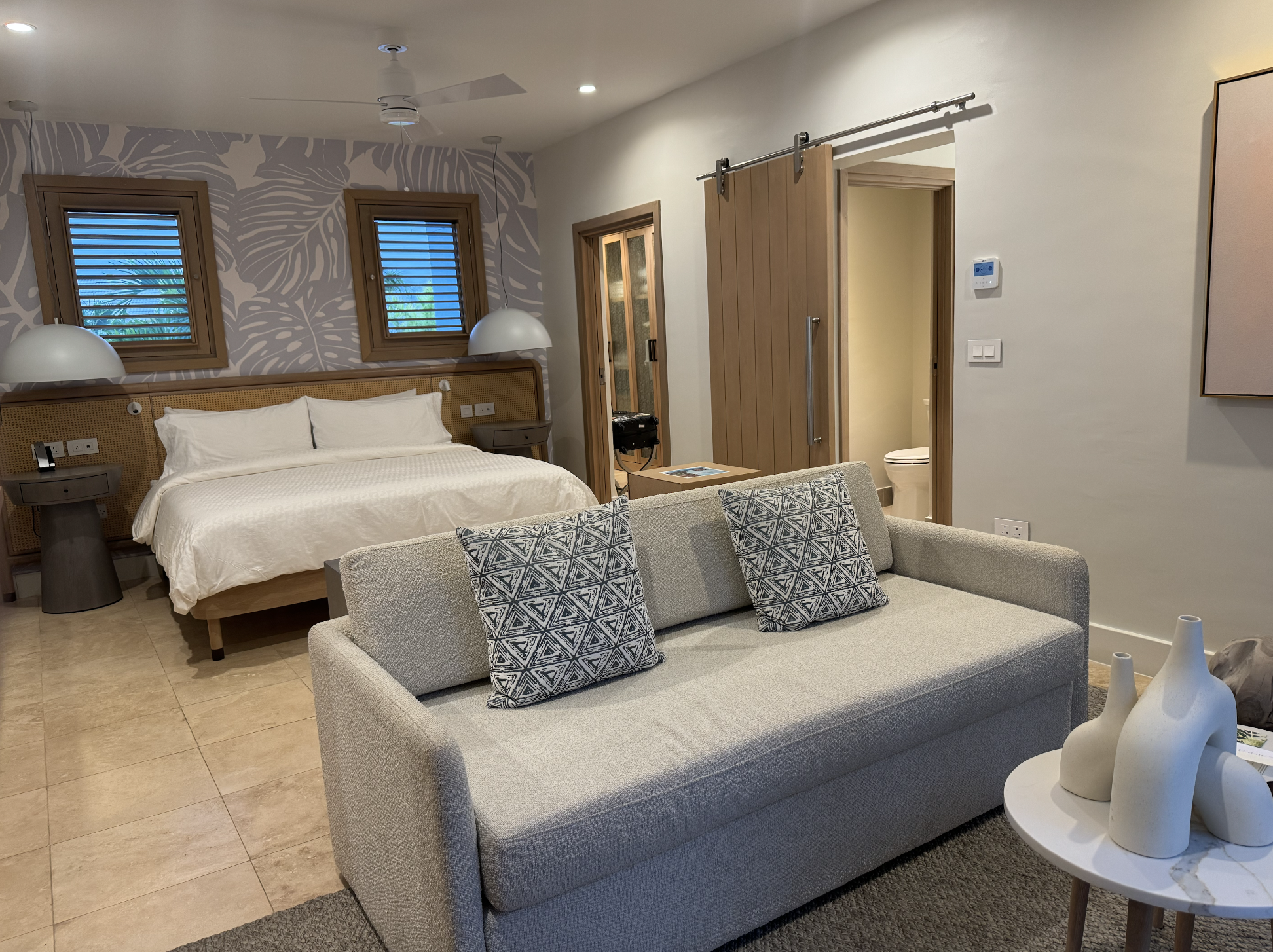 Cama king size e sofá de um dos apartamentos Cama king size e sofá de um dos apartamentos
