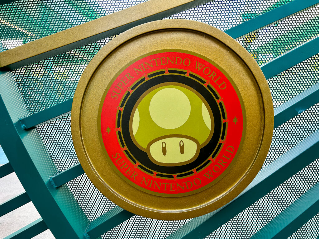 O portão contém um emblema de cada mundo temático