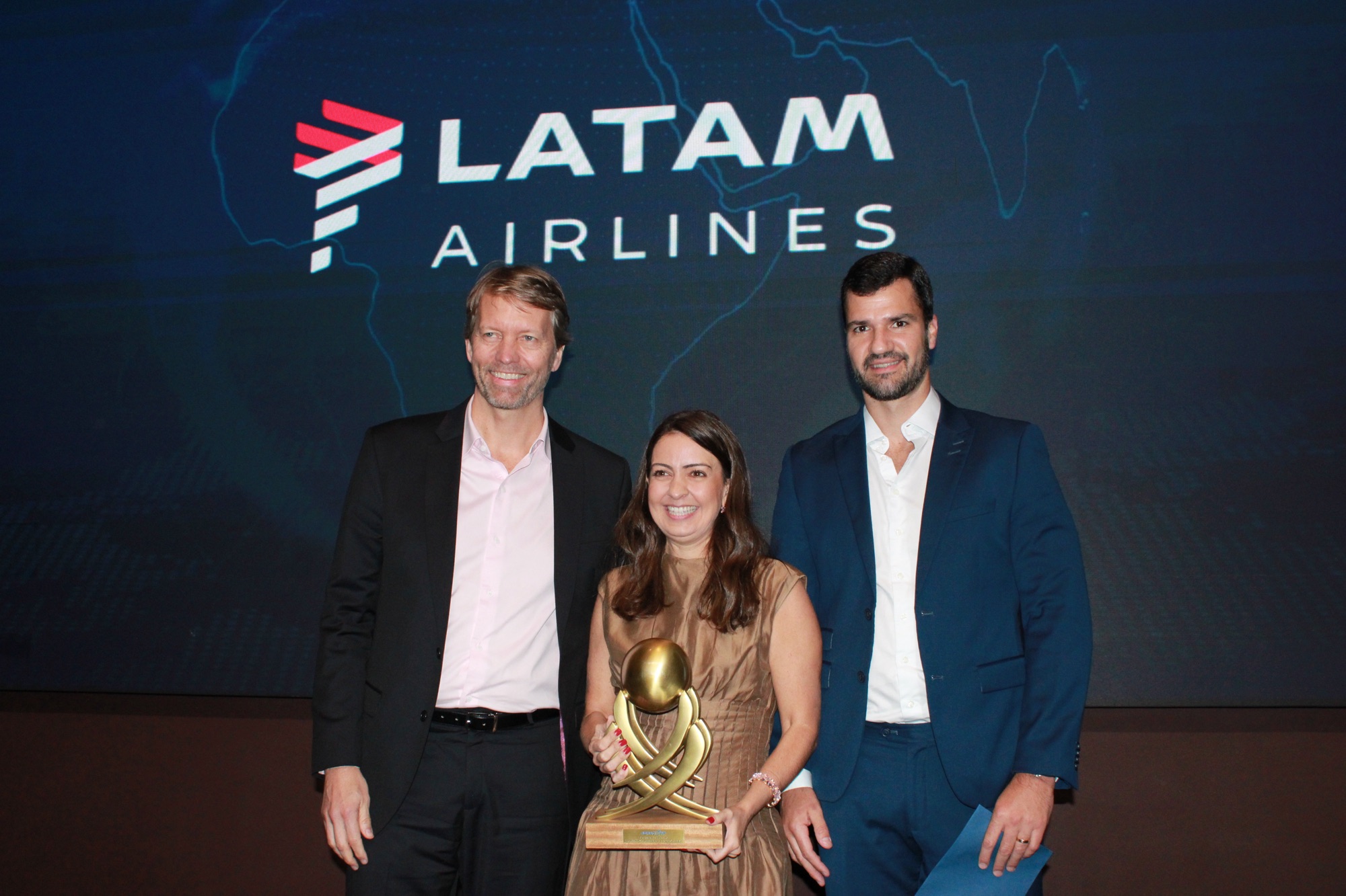 Jerome Cadier e Aline Mafra, da Latam, recebem o prêmio de 'Melhor Companhia Aérea Internacional para América do Sul e Central' das mãos de Rubens Schwartzmann, da Costa Brava (Giulia Jardim/M&E)