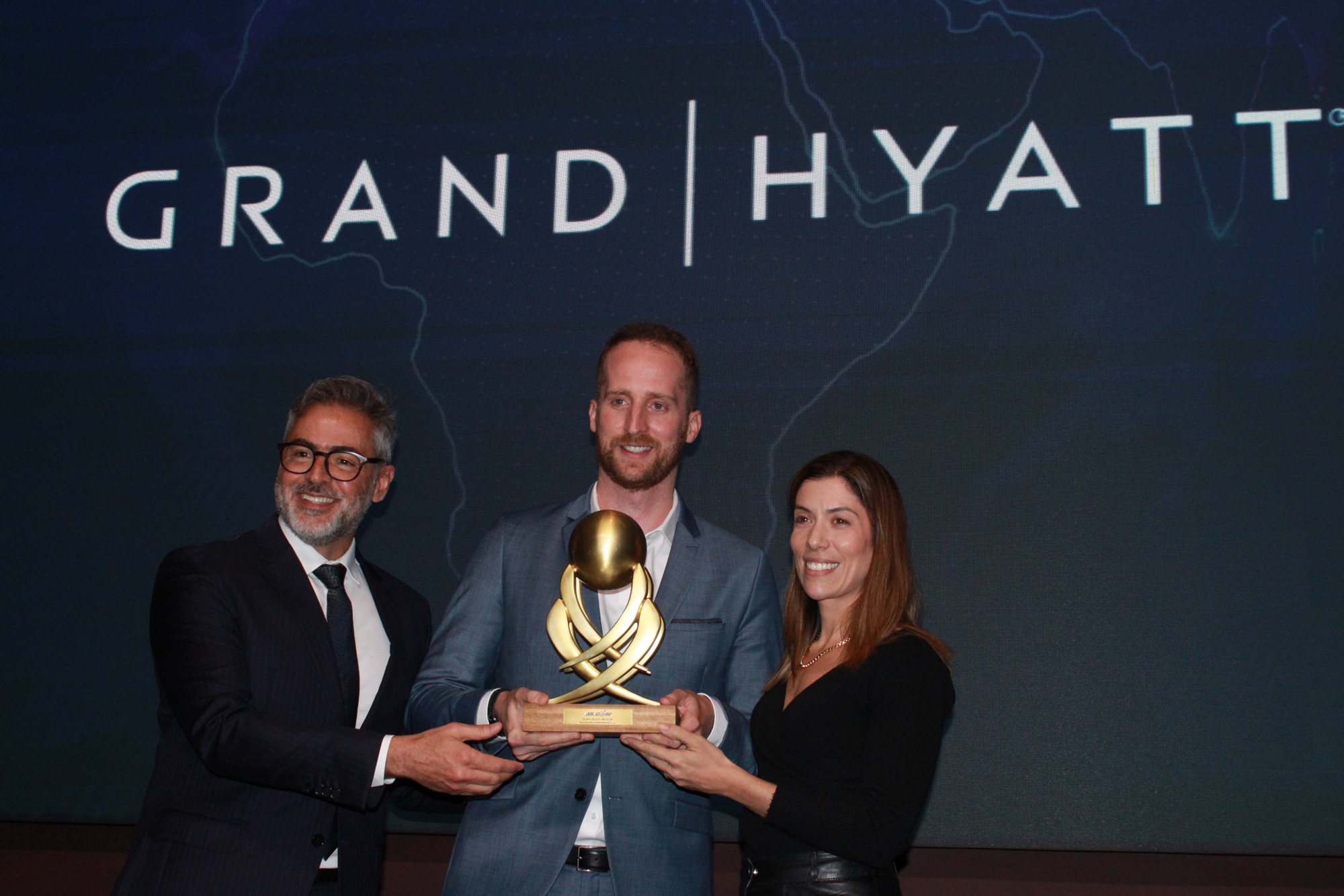 Camilo Crozet e Fernanda Garrido, da Hyatt, recebem prêmio de 'Melhor Rede Hoteleira Internacional' das mãos de Humberto Cançado, da Voetur Turismo (Giulia Jardim/M&E)