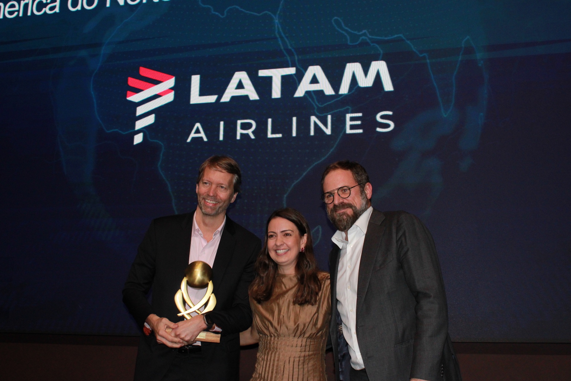 Jerome Cadier e Aline Mafra, da Latam, recebem o prêmio de 'Melhor Companhia Aérea Internacional para a América do Norte' das mãos de Luciano Guimarães, da BeFly (Giulia Jardim/M&E)